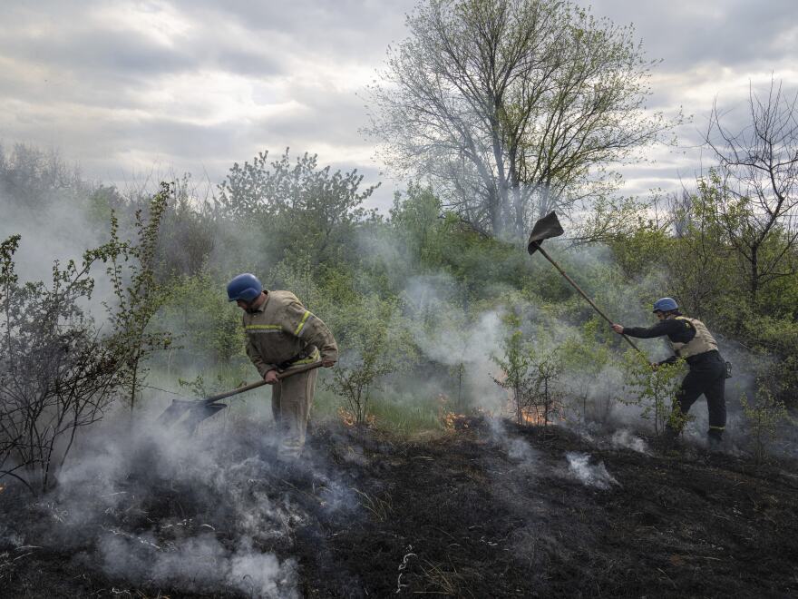 Rescue servicemen extinguish a bush fire after shelling in Mykolaivka, Donetsk region, eastern Ukraine, on Friday.