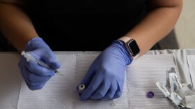 A health care worker fills syringes with doses of the COVID-19 vaccine on Aug. 24 at the Southfield Pavilion in Southfield, Mich.