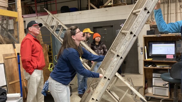 The Cville Tool Library's Kate Scales retrieves a ladder so one patron can clean her home's gutters.