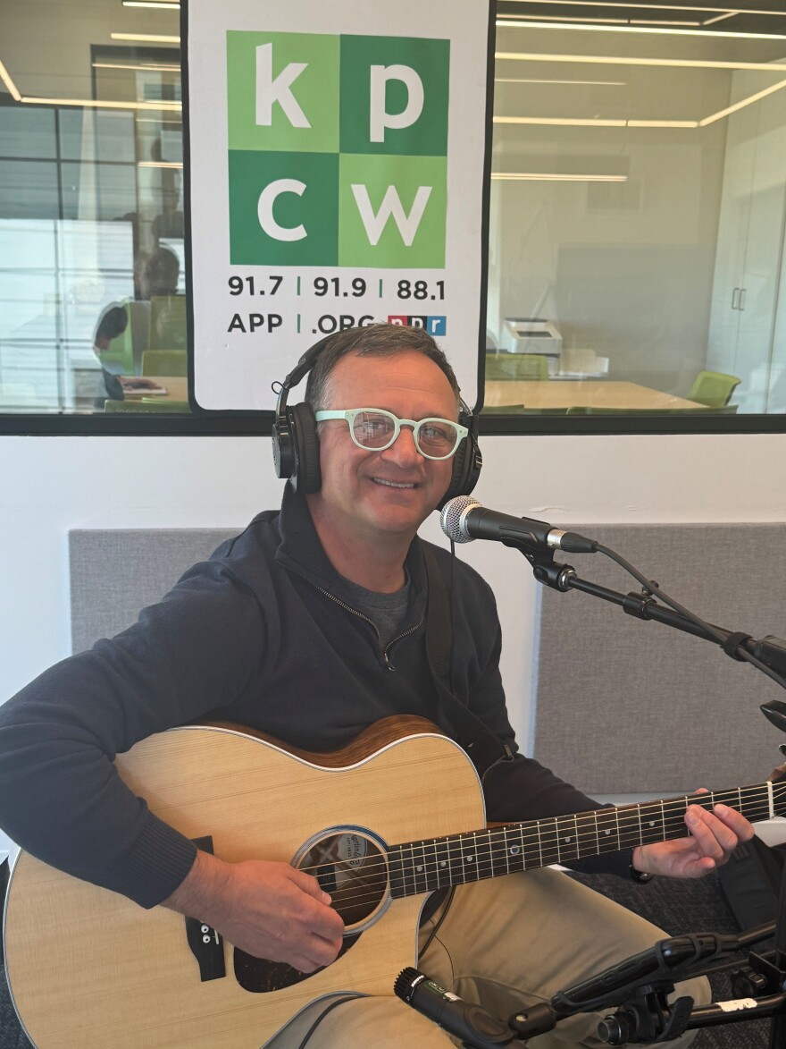 Photo of Ryan Walsh with guitar in the KPCW studio