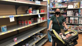 Kelsy Richardson and her daughter, Thea, at empty store shelves.