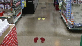 On March 27, a grocery store in Oklahoma City reminds customers via the floor at checkout to stay apart because of concerns over the COVID-19 virus. 