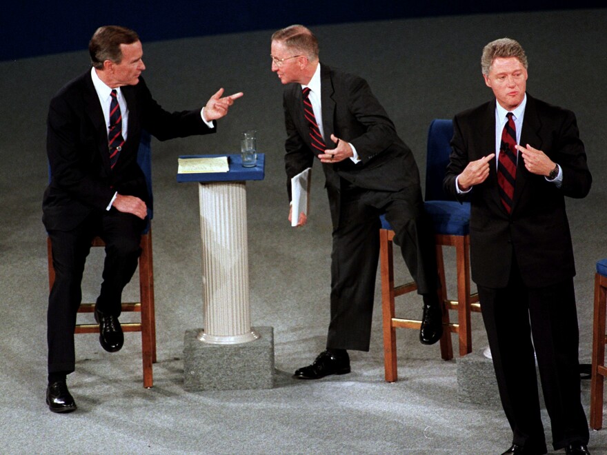 President George Bush, left, talks with independent candidate Ross Perot as Democratic candidate Bill Clinton stands aside at the end of their second presidential debate in Richmond, Va., on Oct. 15, 1992.