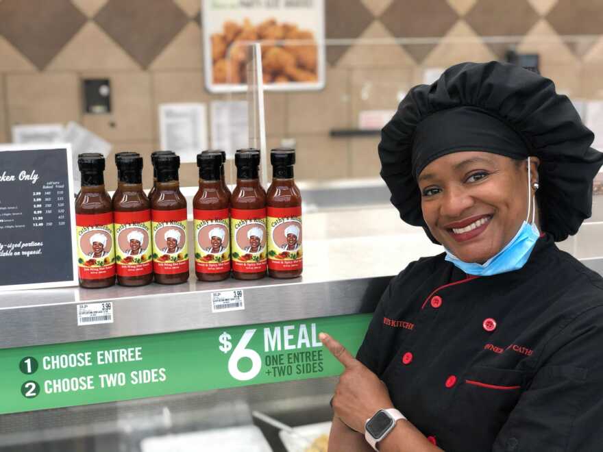 Cathy Jenkins, owner of Cathy’s Kitchen in Ferguson, stands next to her sauces for sale at Schnucks.