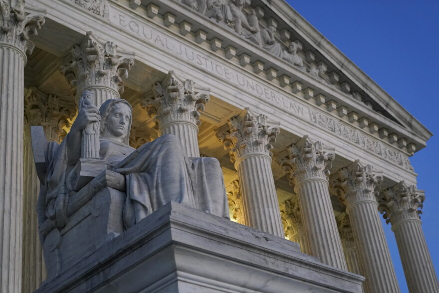 FILE- Light illuminates part of the Supreme Court building on Capitol Hill in Washington, Nov. 16, 2022. The Supreme Court has agreed to hear a Biden administration appeal to limit lawsuits filed by members of Congress against the federal government, in a case that stems from disputes over the Trump International Hotel in Washington. (AP Photo/Patrick Semansky, File)