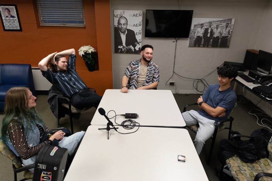 Four young musicians sit around a table.