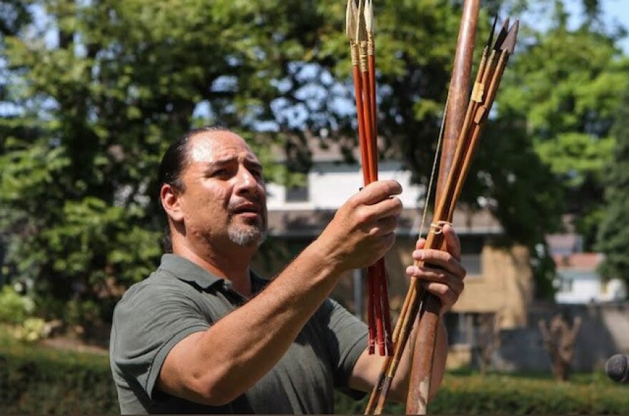 Myron Pourier displays a bow and arrows used by his ancestor, Nicholas Black Elk.