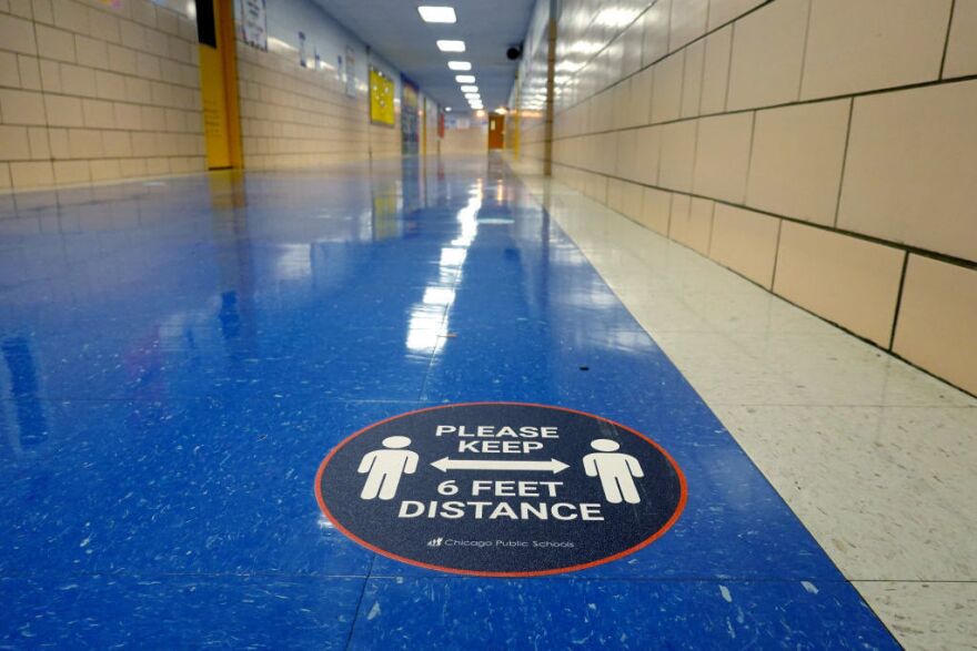 A sign in a hallway at a Chicago elementary school reinforces the mantra of social distancing.