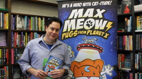 Creator of Max Meow, John Gallagher, poses with copies of the series at The Otto Bookstore in downtown Williamsport.