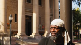 Aaron Williams, a 50-year-old former performer, stands in front of the stage he performed at years ago when visiting Gainesville, Fla., before being struck by homelessness. Williams has been homeless in Gainesville for about a year. (Gabriel Velasquez-Neira/WUFT)