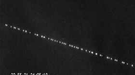 A train of SpaceX Starlink satellites in the night sky.