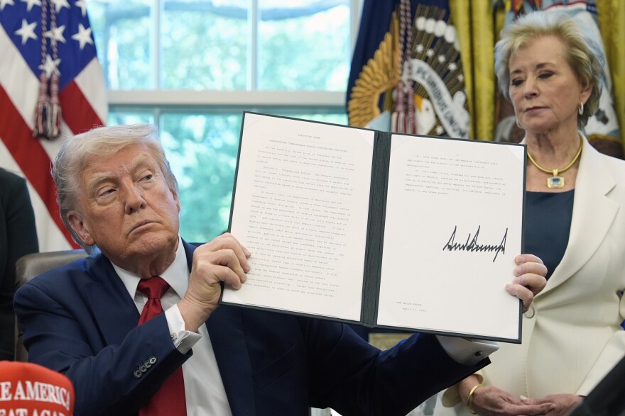 President Donald Trump holds a signed an executive order relating to school discipline policies as Education Secretary Linda McMahon listens in the Oval Office of the White House, Wednesday, April 23, 2025, in Washington.