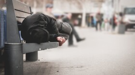 Homeless man sleeping on a public bench