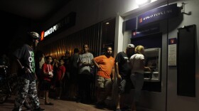People wait in line at an ATM to withdraw money in San Juan, Puerto Rico, on Sept. 25, 2017, where a 7 p.m. to 6 a.m. curfew has been imposed following Hurricane Maria's impact on the island. (Ricardo Arduengo/AFP/Getty Images)