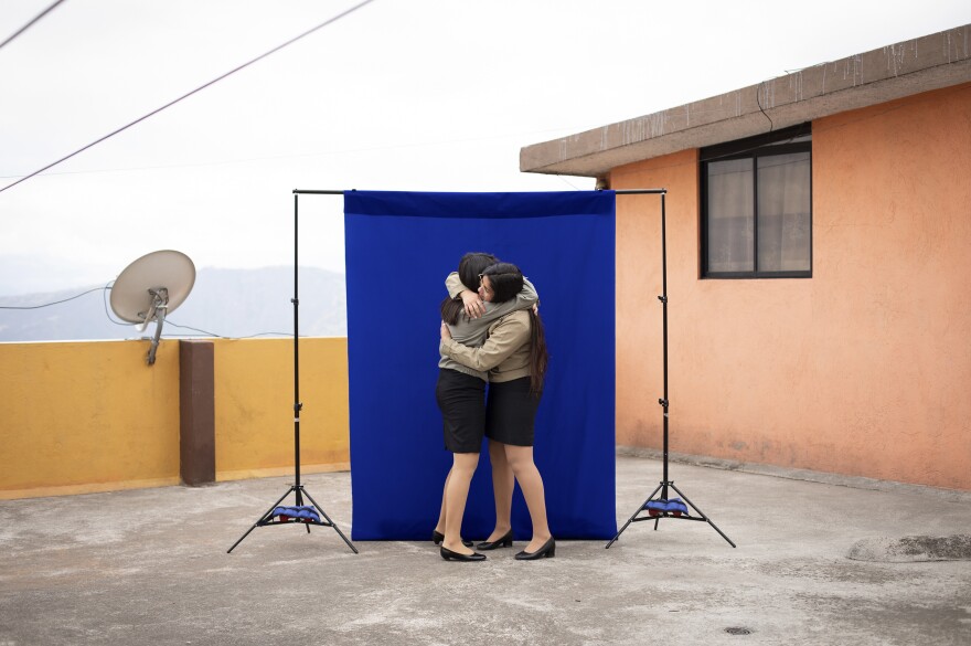 Lisbeth Riera (left), 17, and Leslie Villacís, 18, hug during a pre-graduation portrait session at Leslie's house — the first time the friends had seen each other since a quarantine began four months earlier. The graduation ceremony is off this year "I imagined that I was going to sing the hymn," said Leslie, "that I was going to hug everyone." <em>July 22. Quito, Ecuador.</em>