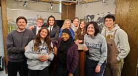 The Newscast class from Spring 2023 that created "Cache Rendezvous: Better Than We Found It" poses for a photo on the A-TV News set. 