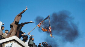 TEHRAN, IRAN - JUNE 1980: A group of hostage holders putting fire on the Amercian flag on the roof of the occupied U.S. embassy during the U.S. hostage crisis which was a diplomatic crisis between Iran and the United States where 52 U.S. diplomats were held hostage for 444 days from November 4, 1979 to January 20, 1981, after a group of Islamist students took over the American embassy in support of the Iranian revolution. (Photo by Reza/Reportage by Getty Images)