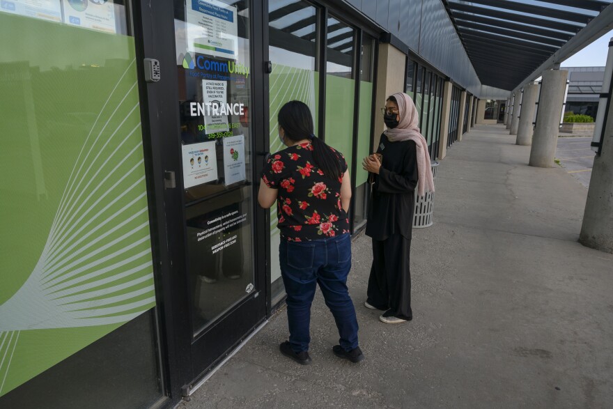 University of Iowa mobile clinic volunteers Hanxi Tang and Sanya Hassan walk around the Broadway neighborhood in Iowa City to find more residents to get the COVID-19 vaccine.