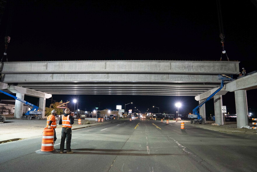 Crews watch the placement of concrete girders for the North South Corridor over Sprague Avenue.