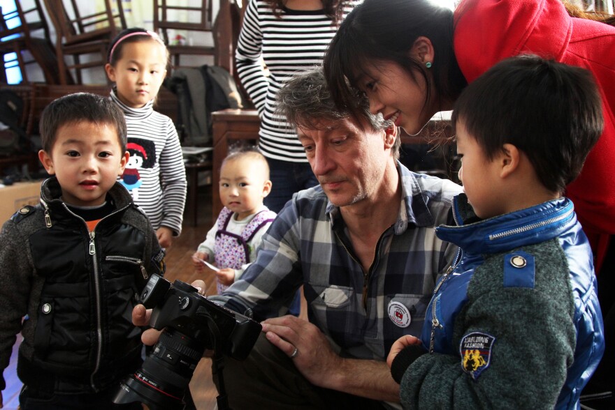 Lutz Michaelis, a robotics engineer from Germany, shows a Chinese family a preview of their free portrait last weekend in Shanghai.
