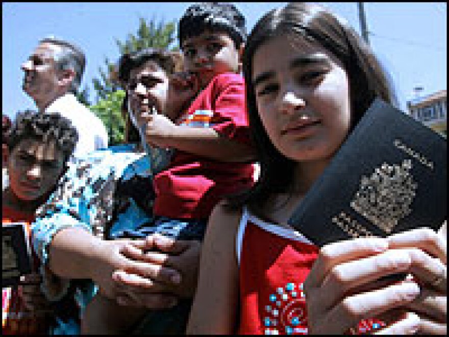 Lebanese-Canadians hold their Canadian passports in front of al-Qaderi hotel in Zahle city in the Bekaa valley as Canadian nationals get ready for evacuation from Lebanon, July 18 2006.