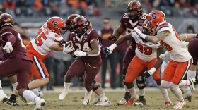 Minnesota running back Mohamed Ibrahim (24) runs past Syracuse defensive back Justin Barron (23) during the first half of the Pinstripe Bowl NCAA college football game Thursday, Dec. 29, 2022, in New York. (AP Photo/Adam Hunger)