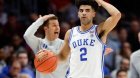 Duke guard Cayden Boozer (2) and head coach Jon Scheyer call a play during the first half of an NCAA college basketball game against Florida State in the quarterfinals of the Atlantic Coast Conference tournament in Charlotte, N.C., Thursday, March 12, 2026.