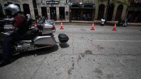 A biker rides past blood stains on East Sixth Street. 