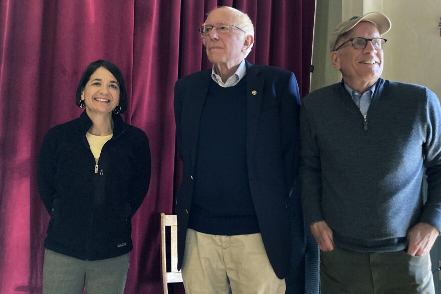 A woman and two men stand in a line