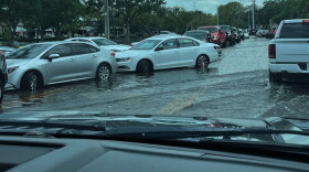 cars try to get through a flooded road