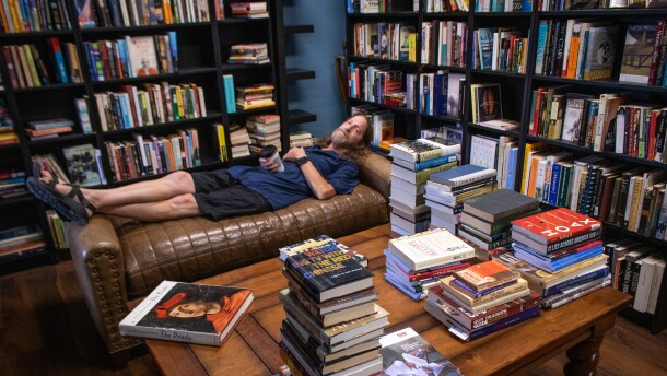 Underground Books owner D.S. Andersen demonstrates the comfort of the furniture in his Ogden shop’s reading room, July 17, 2026.