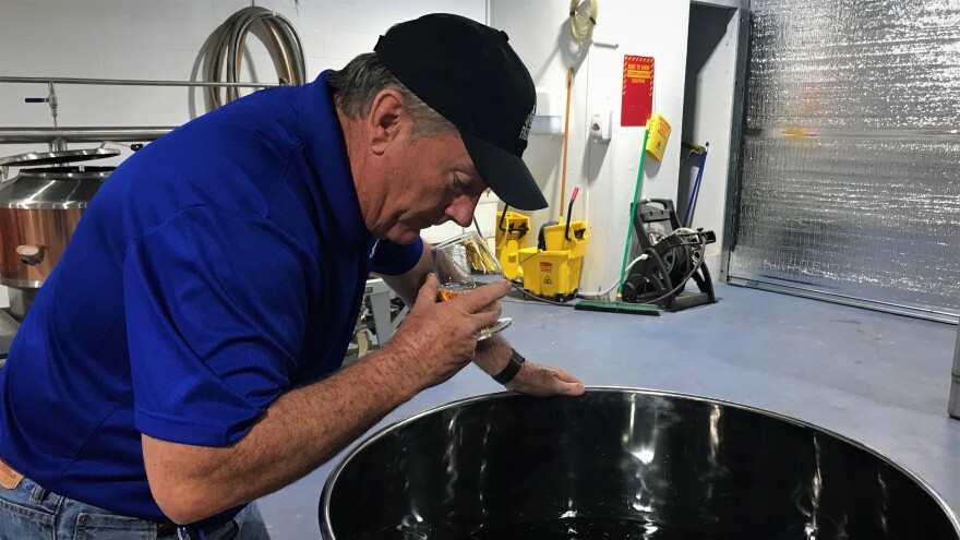 Four Fathers Distillery owner Tim Daniels smelling a batch of his Black Copper Rum.