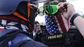 In this file photo, a member of the Proud Boys, right, stands in front of a counter protester as members of the Proud Boys and other right-wing demonstrators rally on Sept. 26, 2020.