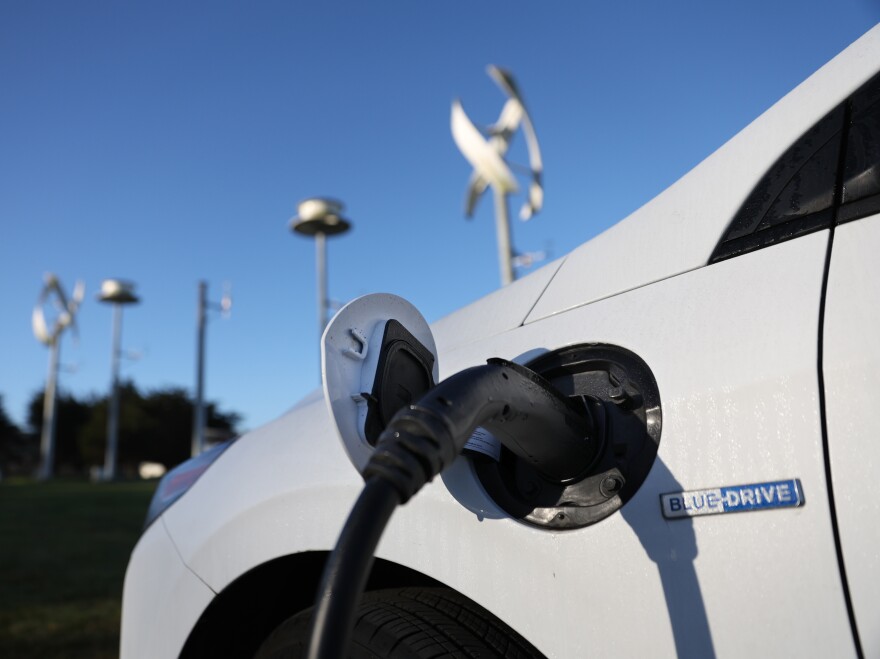 An electric vehicle gets its battery recharged at a charge station.