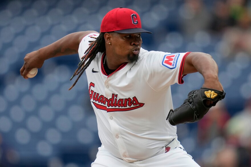 Luis Ortiz is shown mid-pitch while wearing a Cleveland Guardians white home uniform.