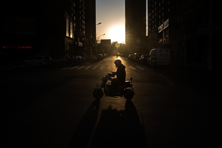 A courier at dusk. According to Chinese state media, people have mixed feelings about the couriers. Some feel grateful to them for providing supplies during this time of crisis. Others are afraid the workers may transmit the virus because they're traveling to a lot of places in the city and touching many packages a day.