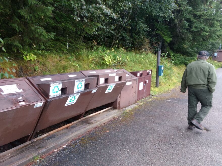 Glacier Bay National Park utilities supervisor Mark Ortega walks past a row of recycling bins on Sept. 5 near the National Park Service’s visitors center at Bartlett Cover (Photo by Jacob Resneck/KTOO)
