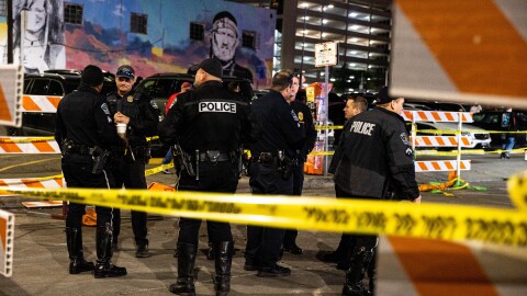Austin Police gather on 6th Street with crime tape surrounding them.