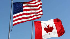 An American & Canadian flag waving in the wind.