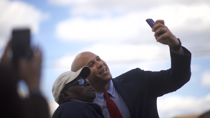 Sen. Cory Booker takes a photo with a supporter as he arrives at a campaign event for former Secretary of State Hillary Clinton in February.