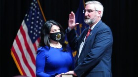 Eric Holcomb is sworn in as Indiana's governor by Chief Justice Loretta H. Rush on a bible held by his wife, Janet, during an inaugural ceremony at the Indiana State Museum, Monday, Jan. 11, 2021, in Indianapolis.