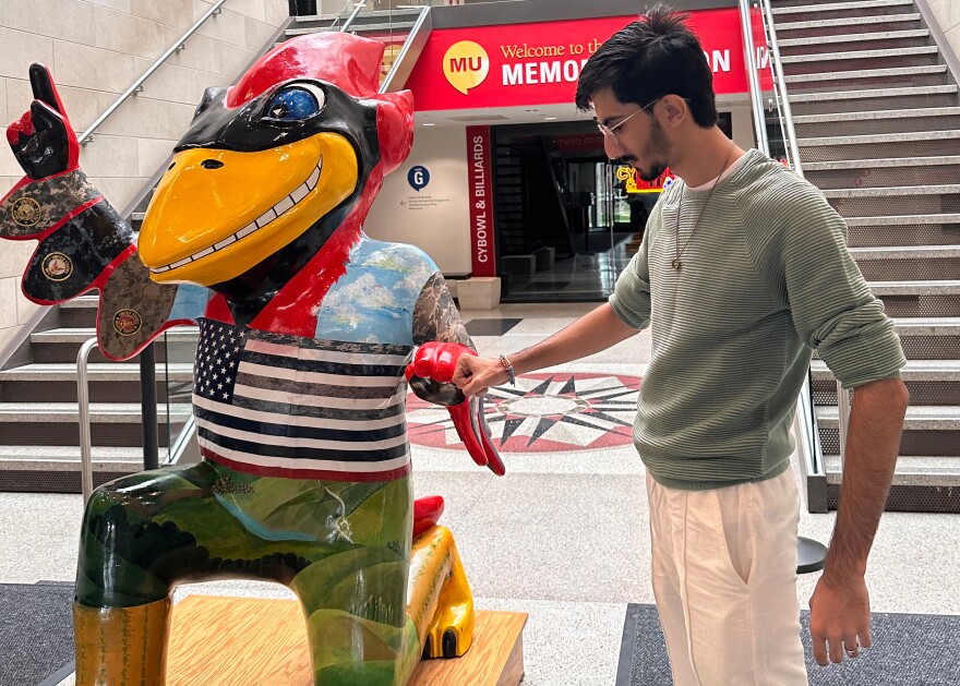 Daniyal Shahbaz, a native of Pakistan, stands next to the Iowa State University mascot inside the school’s Memorial Union building during fall freshman orientation in 2024.