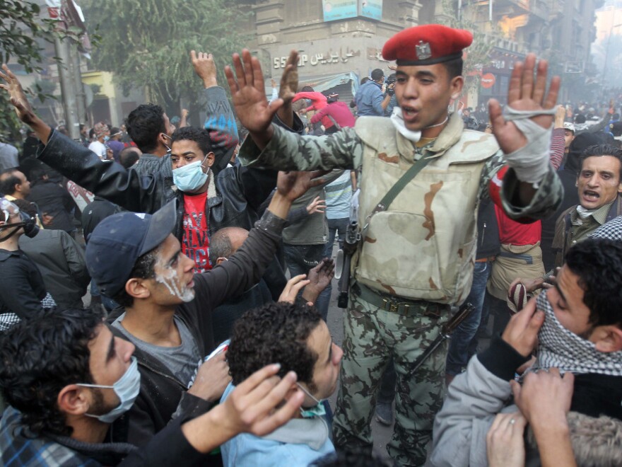 An Egyptian soldier tries to calm protesters during demonstrations Tuesday in Cairo's Tahrir Square. The protesters are demanding an end to military rule.