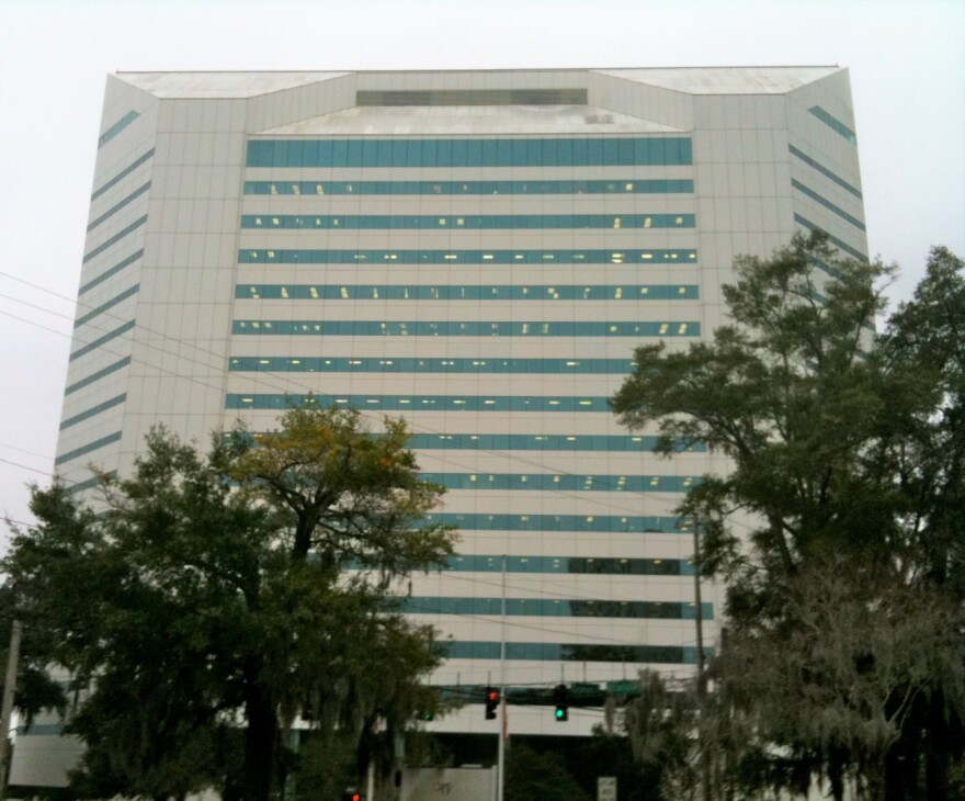 Exterior of a tall white building with trees in the foreground