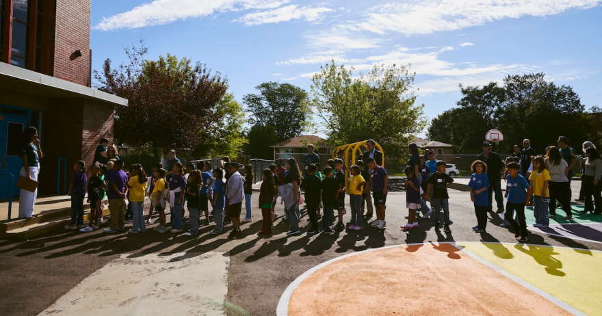 Students line up outside a playground.