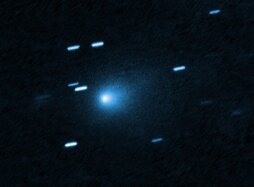 This is a Hubble Space telescope image of the interstellar comet 3I/ATLAS. Hubble photographed the comet on 21 July 21 2025, when the comet was 365 million kilometres from Earth. Hubble shows that the comet has a teardrop-shaped cocoon of dust coming off its solid, icy nucleus. Because Hubble was tracking the comet moving along a hyperbolic trajectory, the stationary background stars are streaked in the exposure. [Image description: At the center of the image is a comet that appears as a teardrop-shaped bluish cocoon of dust coming off the comet’s solid, icy nucleus and seen against a black background. The comet appears to be heading to the bottom left corner of the image. About a dozen short, light blue diagonal streaks are seen scattered across the image, which are from background stars that appeared to move during the exposure because the telescope was tracking the moving comet.]