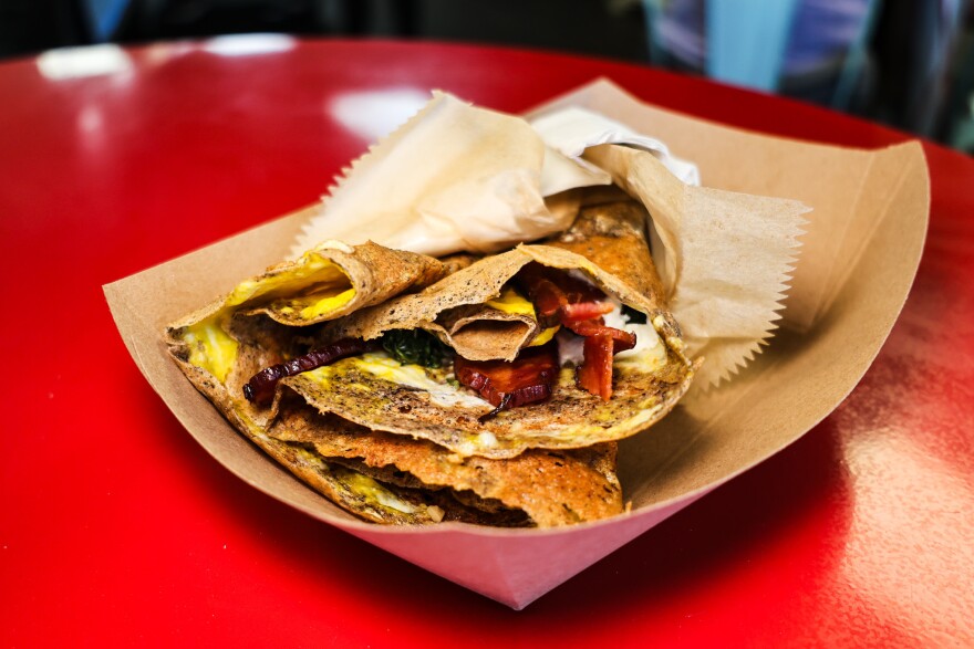 A photo of a buckwheat crepe with spinach, ham, cheese, and egg.