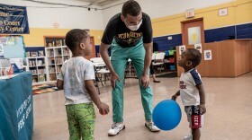 Jaz-Munn “Jaz” Johnson plays with a child during a healthy baby clinic at the Whitcomb Court Park and Recreation Center, 2302 Carmine St, Richmond, Va. Whitcomb Court is a public housing community.