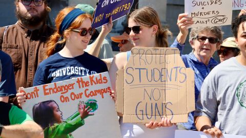 Opponents of barring gun restrictions on college campuses in New Hampshire rally Tuesday before a N.H. Senate hearing on the bill