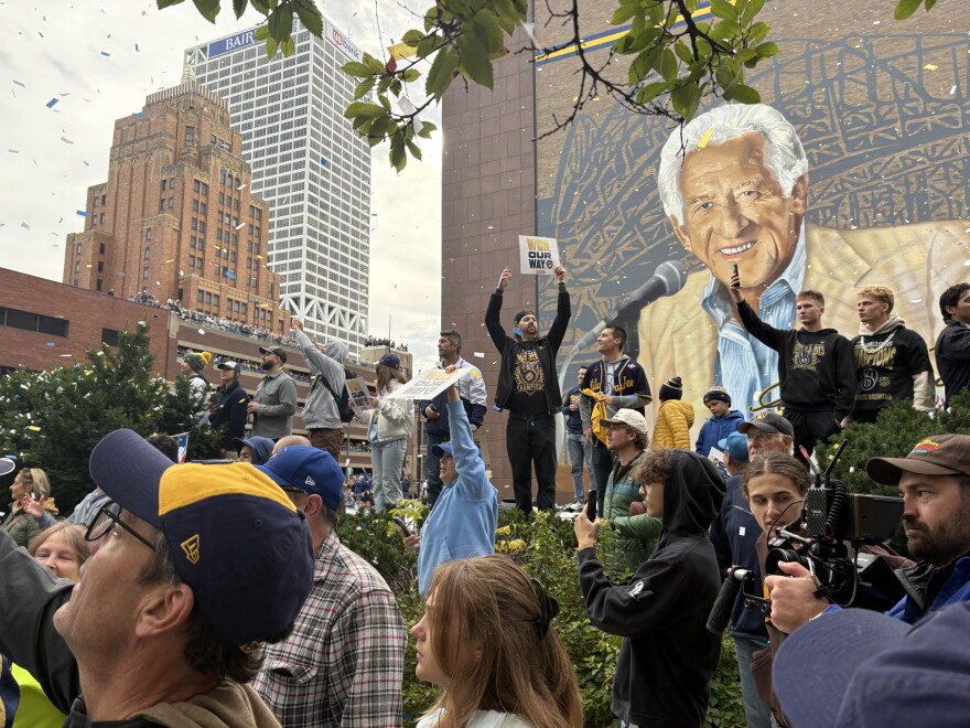 Brewers fans celebrate in front of the Bob Uecker mural on Jackson Street in downtown Milwaukee.